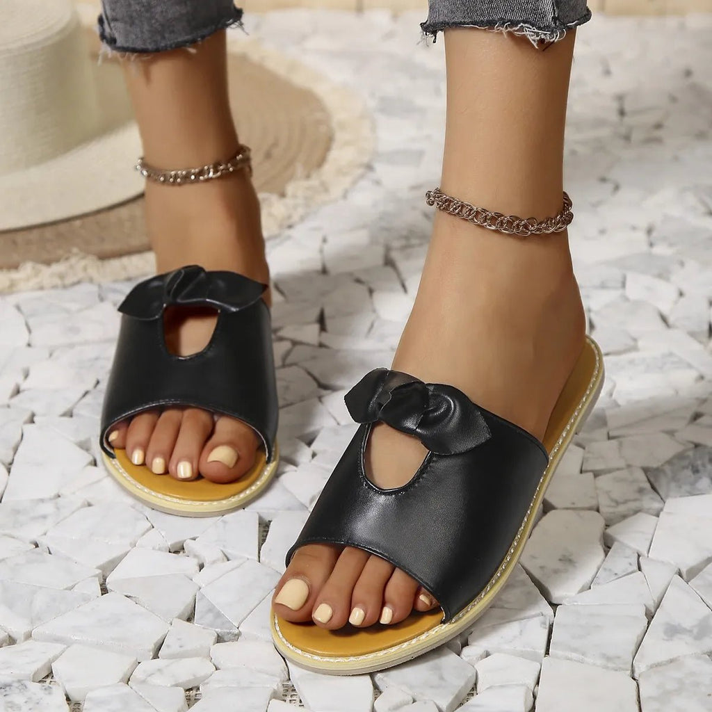 Women's casual open-toe faux leather flats with cutout details, designed for comfortable summer wear.