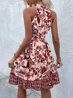 Printed sleeveless tie waist dress by Shopimist featuring a vibrant floral pattern and lightweight fabric.