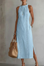 Women's sleeveless maxi dress with side slit and pockets by Plush Fashion Hub, shown in a flowing fabric with a stylish design.