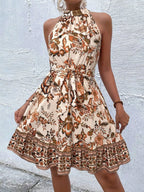 Printed sleeveless tie waist dress by Shopimist, showcasing a stylish pattern, sleeveless design, and a waist tie detail on a model.