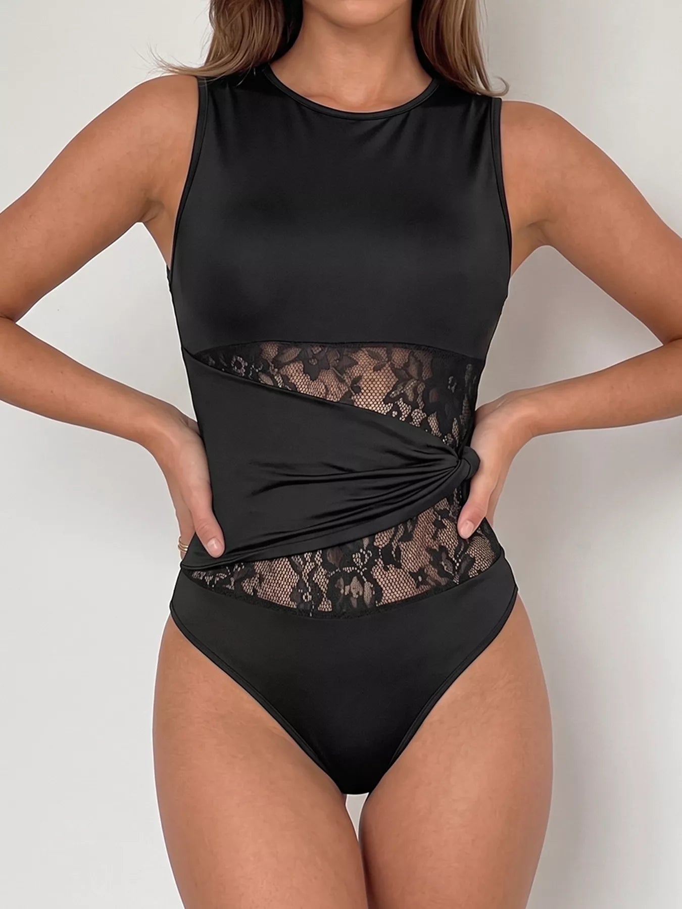 Sheer lace panel sleeveless bodysuit from Plush Fashion Hub, featuring delicate lace details and a fitted sleeveless design.