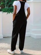 Casual loose-fit spaghetti strap jumpsuit with pockets by Trendsi, shown in a relaxed fit with adjustable straps and side pockets.