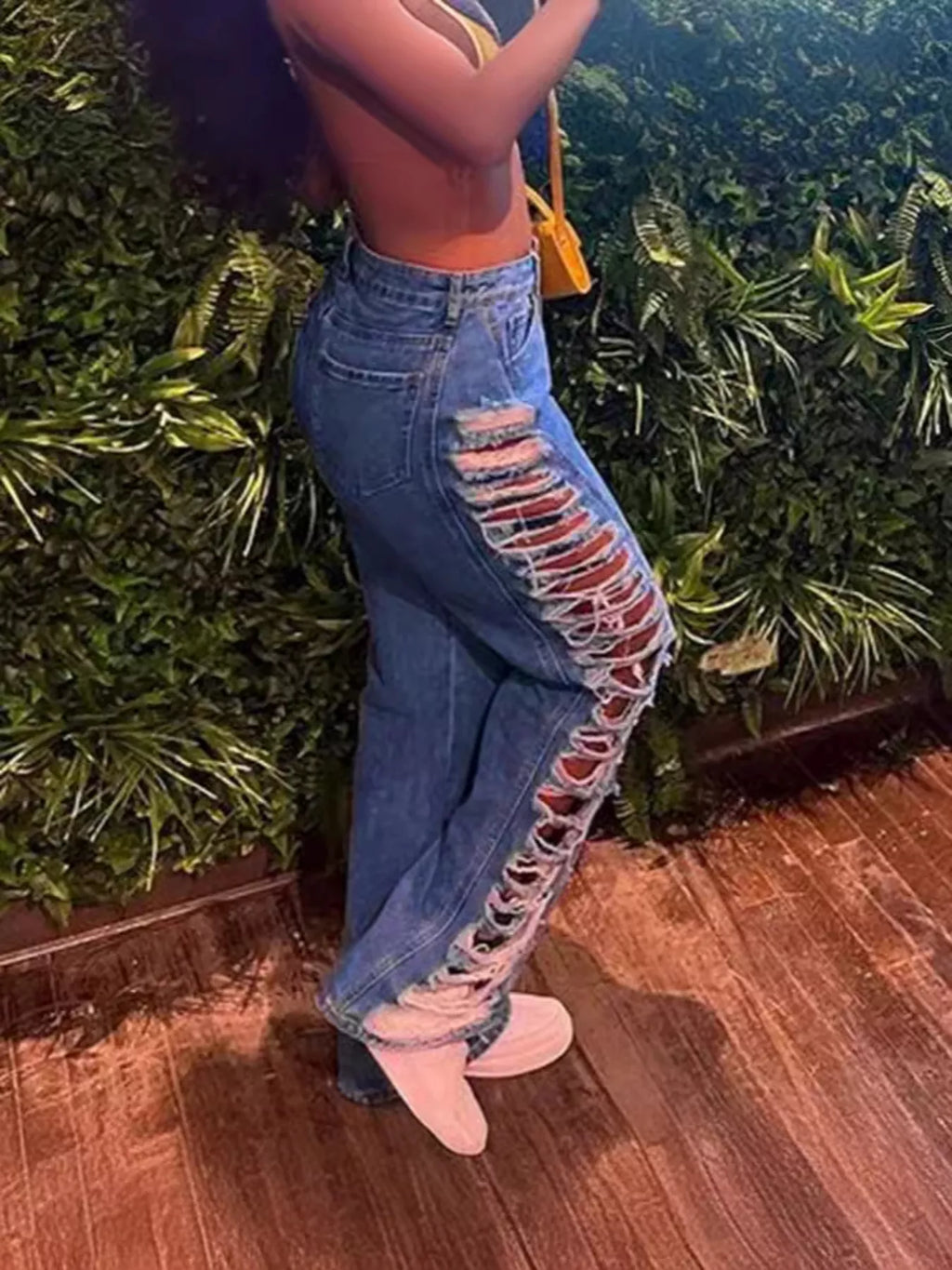 Distressed denim jeans by Plush Fashion Hub featuring ripped details and a classic fit, shown in a side view.