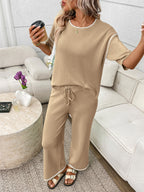 Women's casual two-piece lounge set with round neck top and drawstring pants, trending fashion by Trendsi.