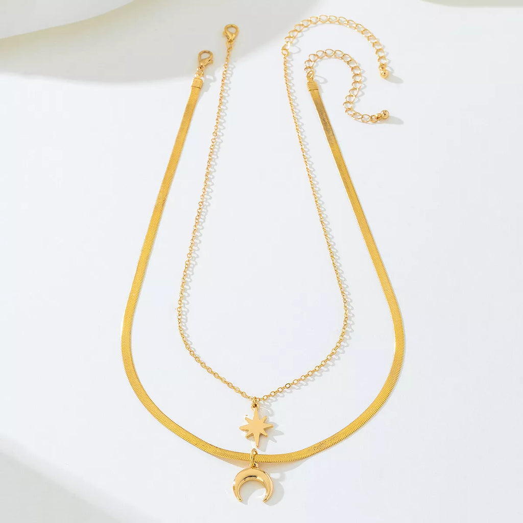Gold-plated moon and star necklace set featuring two delicate pendants, perfect for layered jewelry styles.