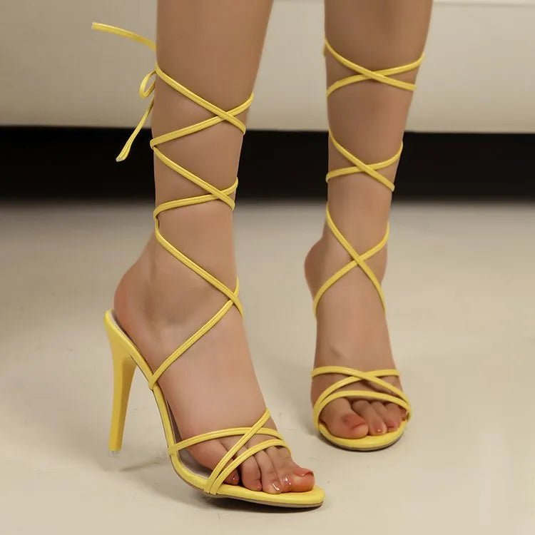 Women's black cross-strap stiletto high heel sandals from Trendsi, featuring elegant evening footwear design and open toe style.