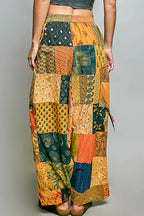 Printed patchwork wide-leg cotton pants with side drawstring, styled as a dress, featuring colorful patterns and relaxed fit.