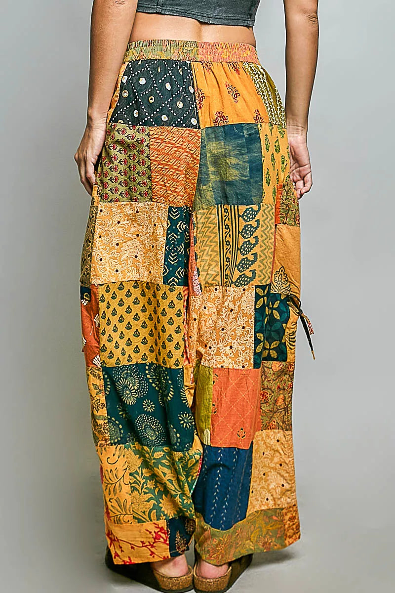 Printed patchwork wide-leg cotton pants with side drawstring, styled as a dress, featuring colorful patterns and relaxed fit.
