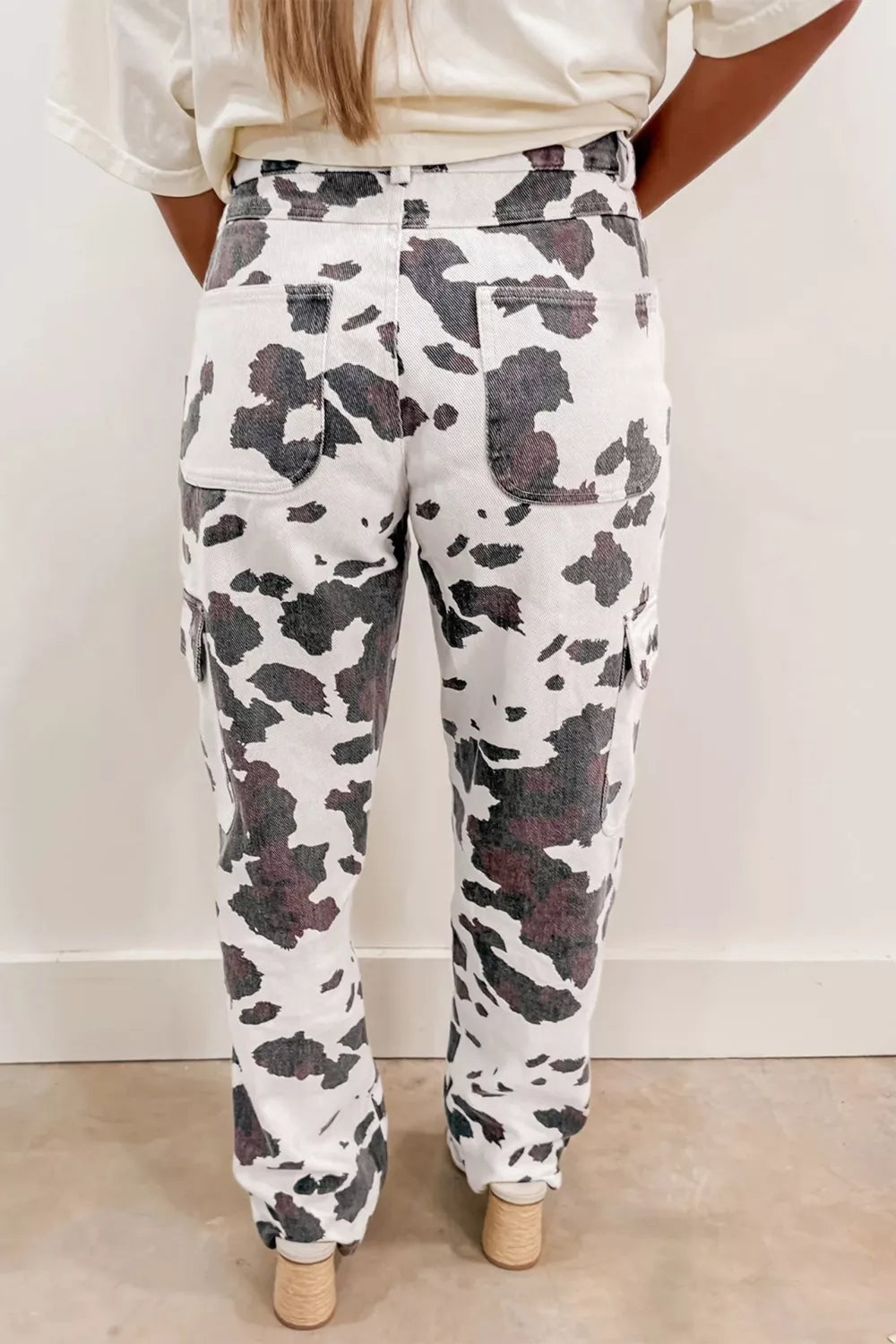 Cow spots printed multi-pocketed jeans from Plush Fashion Hub featuring cow print pattern and multiple functional pockets.