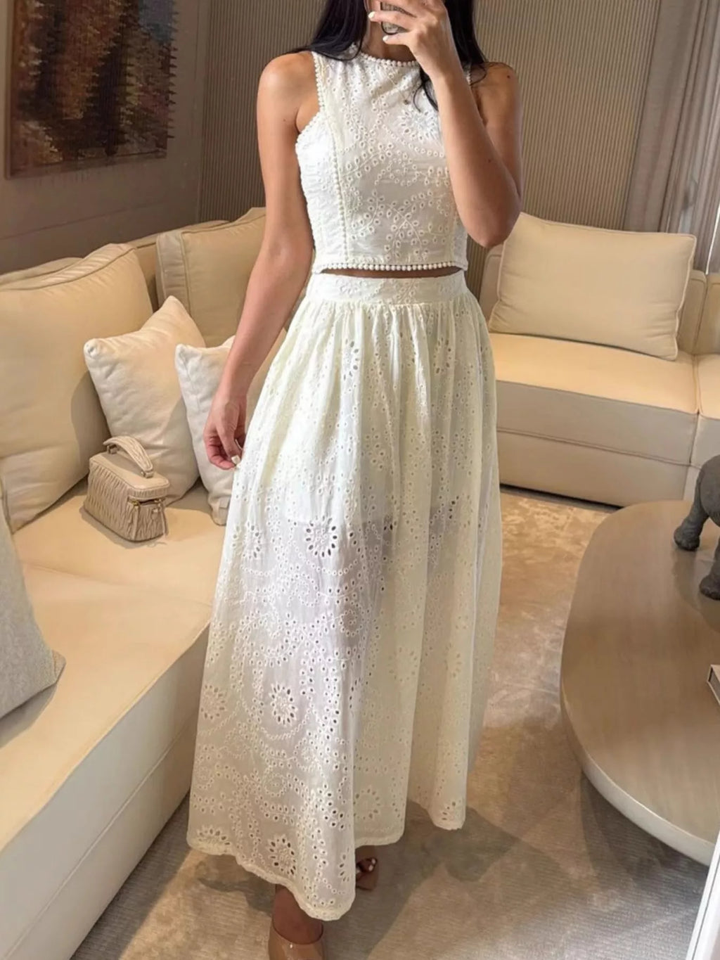 Eyelet crop top and maxi skirt set from Trendsi, featuring matching white fabric with eyelet details and a stylish, coordinated look.
