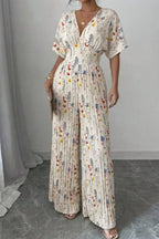 Floral print wide-leg pleated jumpsuit from Trendsi, featuring a flowing design and stylish pattern, shown on a model.