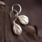 Sterling silver drop earrings with elegant teardrop design, crafted by Shopimist, featuring polished, shiny silver finish.