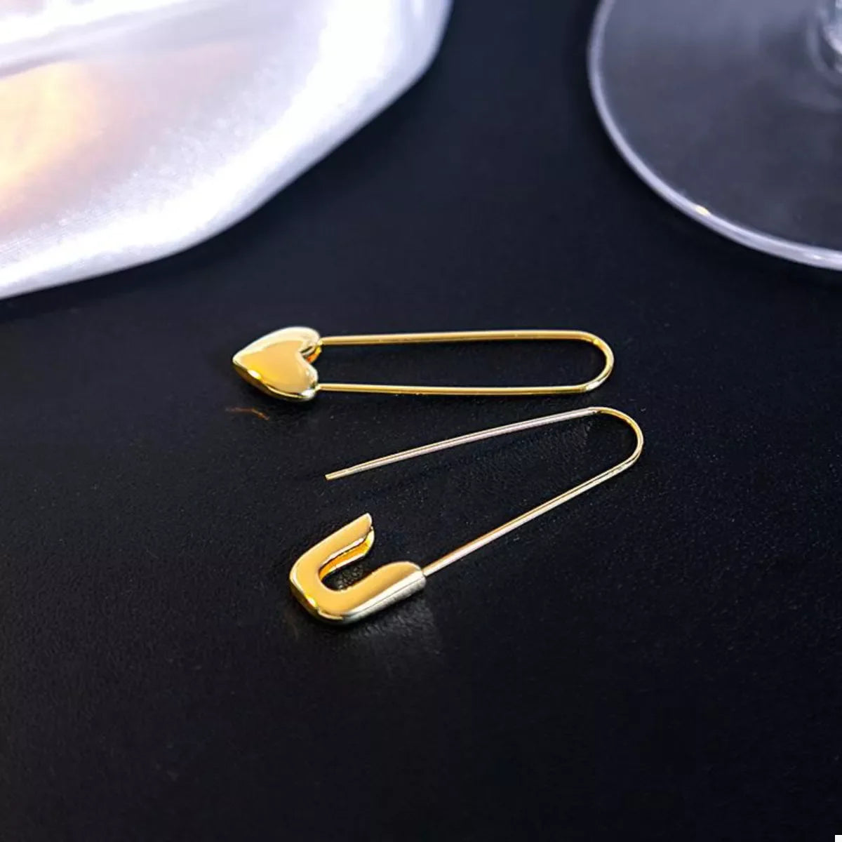 Gold-plated alloy heart safety pin drop earrings, stylish and elegant jewelry by Plush Fashion Hub, featuring unique design details.