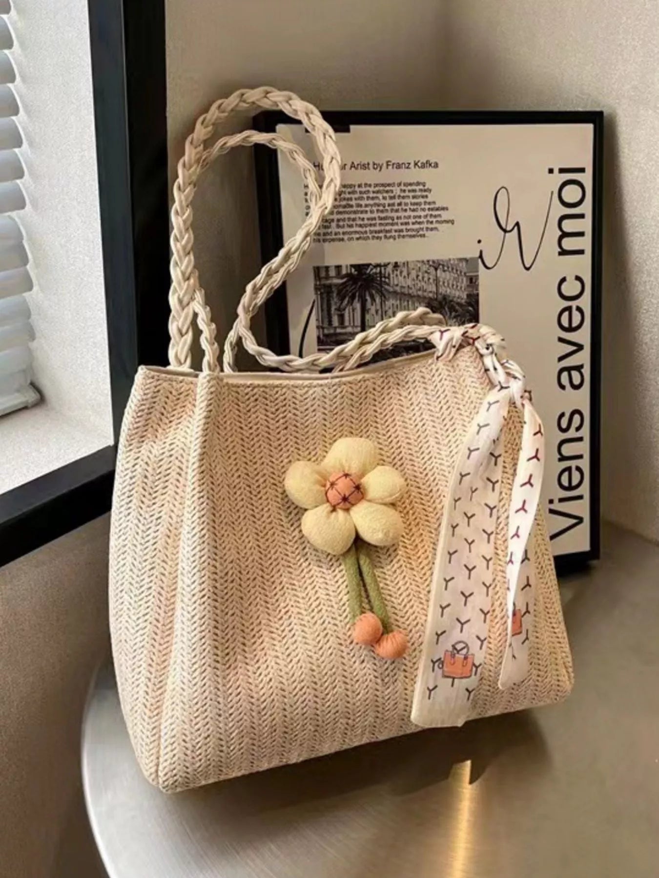 Woven straw tote bag with floral decor, featuring a spacious design and sturdy handles, perfect for summer outings.
