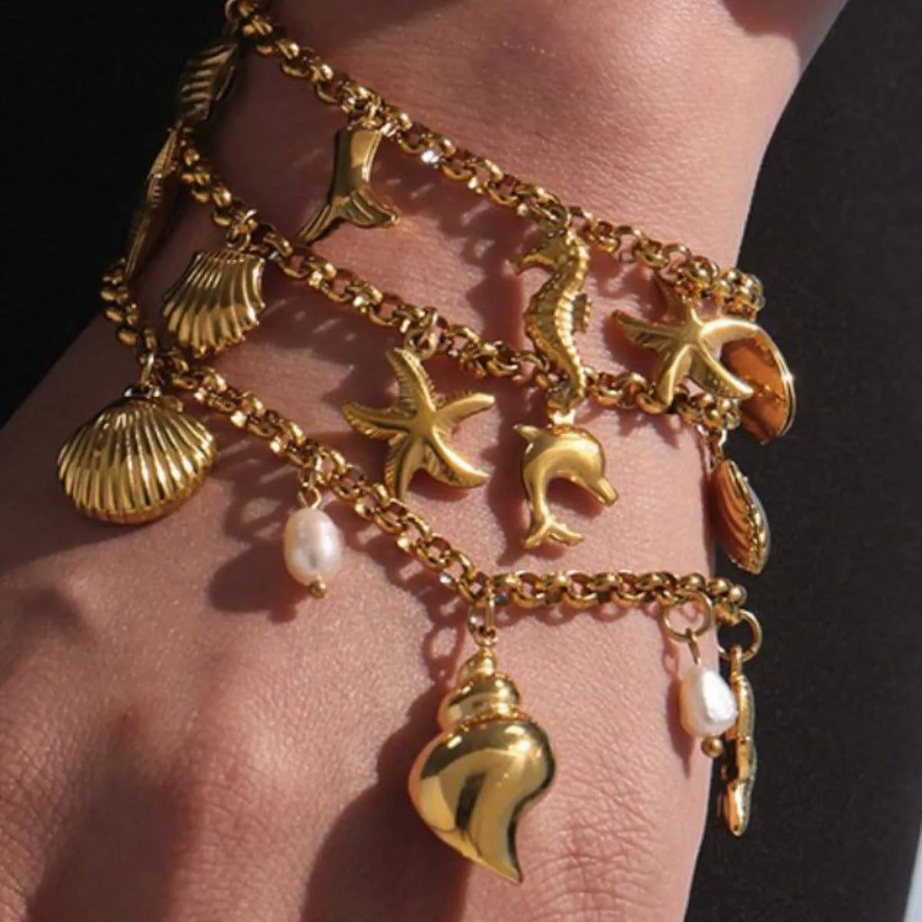 18K gold-plated sea shell charm bracelet with delicate chain and ocean-inspired shell charms, stylish jewelry accessory.