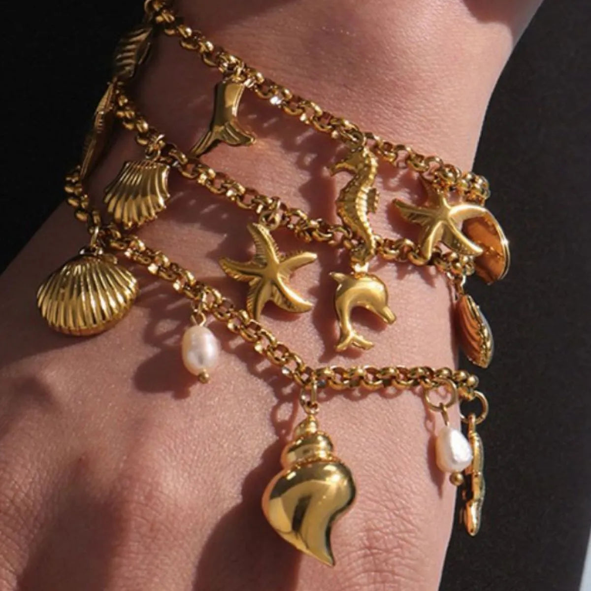 18K gold-plated sea shell charm bracelet with delicate chain and ocean-inspired shell charms, stylish jewelry accessory.