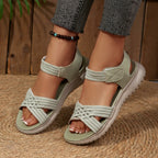 Women's open toe woven strap flat sandals by Trendsi, featuring comfortable faux leather slides with stylish woven detailing.