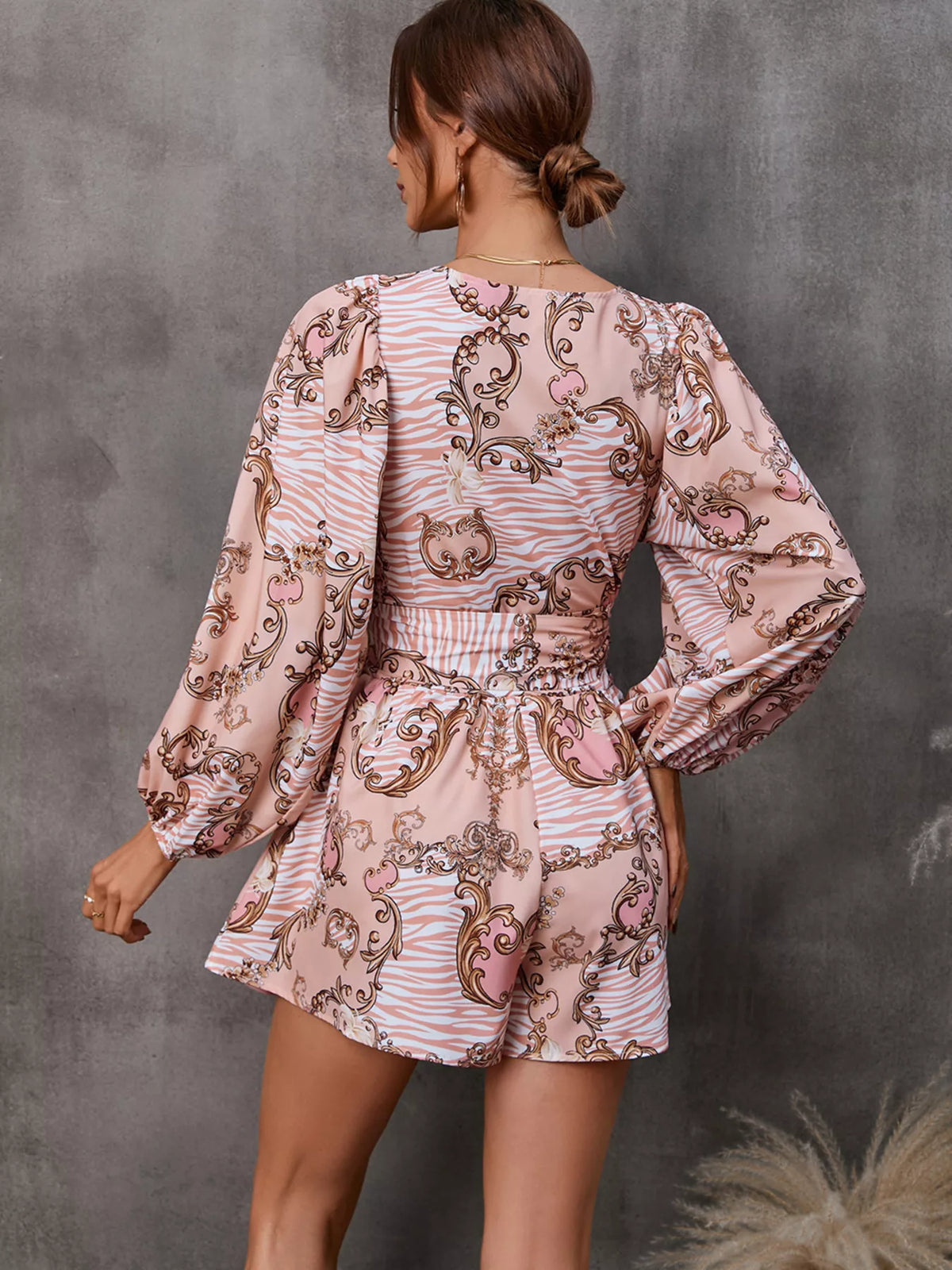 Printed long sleeve romper with front cutout, stylish jumpsuit by Plush Fashion Hub, shown on a model with a modern, trendy look.