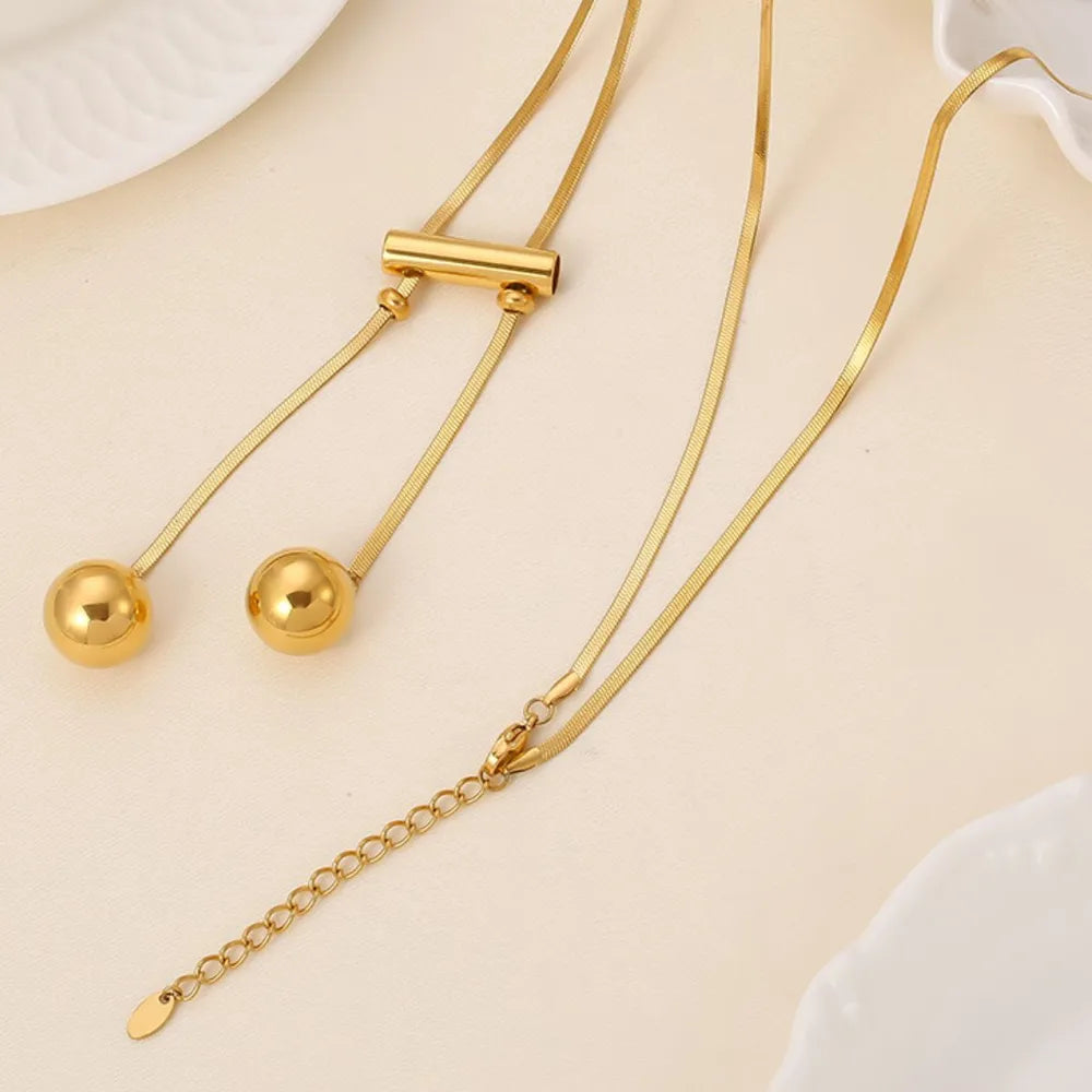 18K gold-plated titanium steel hollow bead necklace with smooth, shiny finish and modern design, featuring spherical beads.