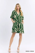 Umgee leafy ogee print mini dress with long sleeves and a fitted silhouette, featuring a vibrant green and white pattern.