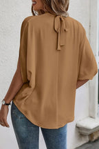 Plush Fashion Hub elegant tie-back half-sleeve blouse with side slit, showcasing a stylish fit and lightweight fabric.