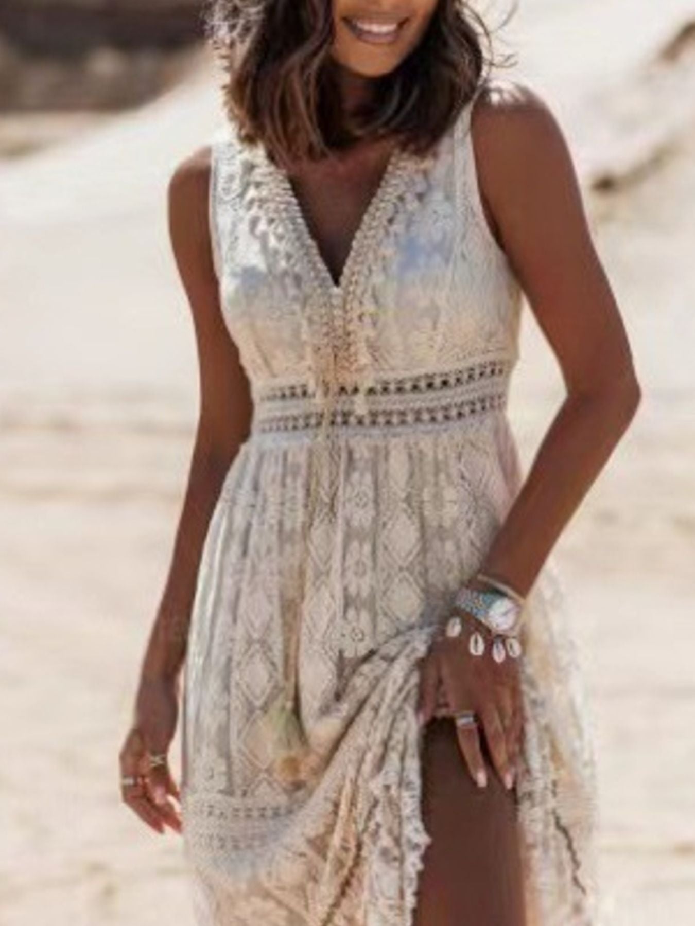Ethereal V-neck lace sleeveless maxi dress with tassel accents, flowing fabric, and intricate lace details, perfect for elegant occasions.