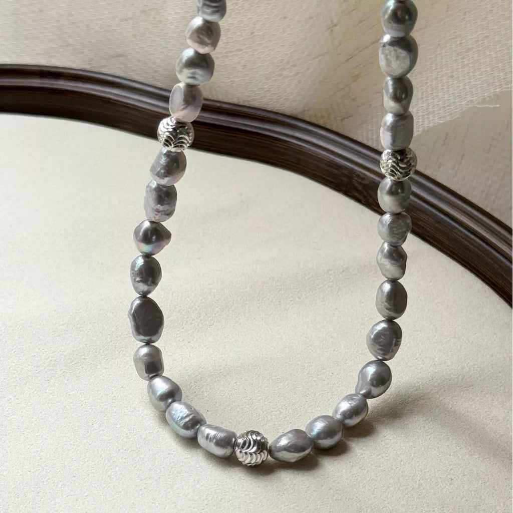 Elegant pearl choker necklace from Shopimist featuring a string of lustrous white pearls on a delicate black ribbon.