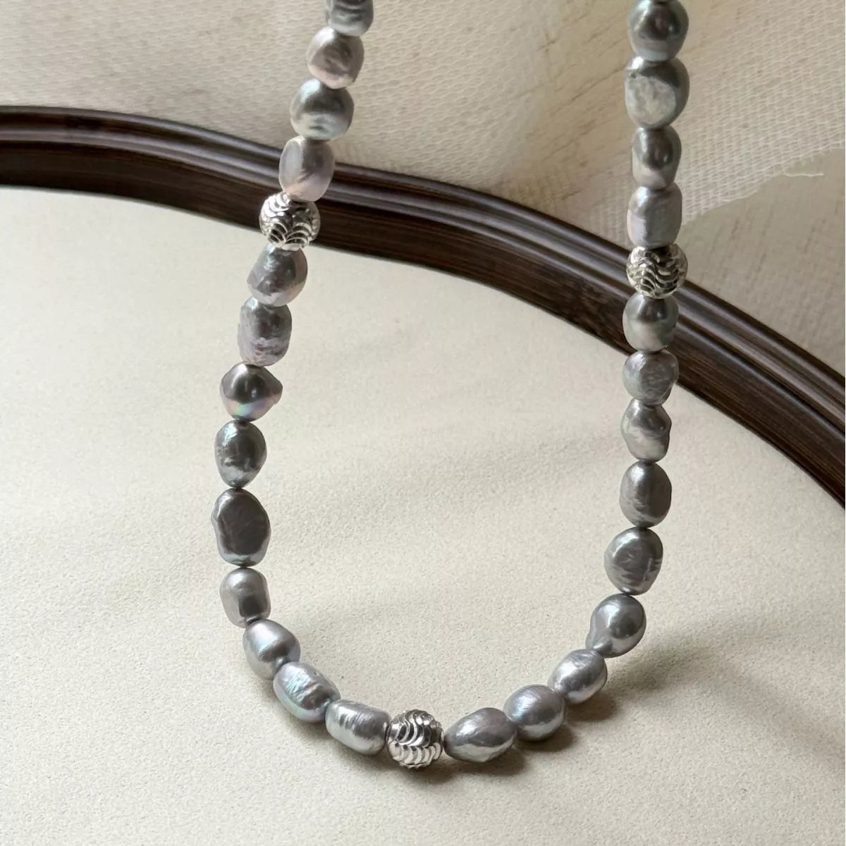 Elegant pearl choker necklace from Shopimist featuring a string of lustrous white pearls on a delicate black ribbon.