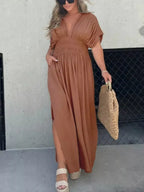 Plus size maxi dress with slit, v-neck, and smocked waist from Trendsi, featuring a full-length flowy design and elegant style.