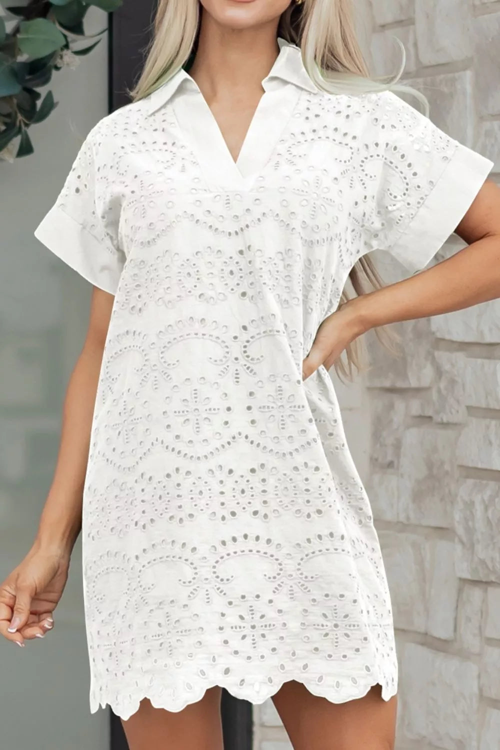 Solid color eyelet embroidered mini dress by Trendsi featuring a stylish T-shirt design and decorative eyelet details.