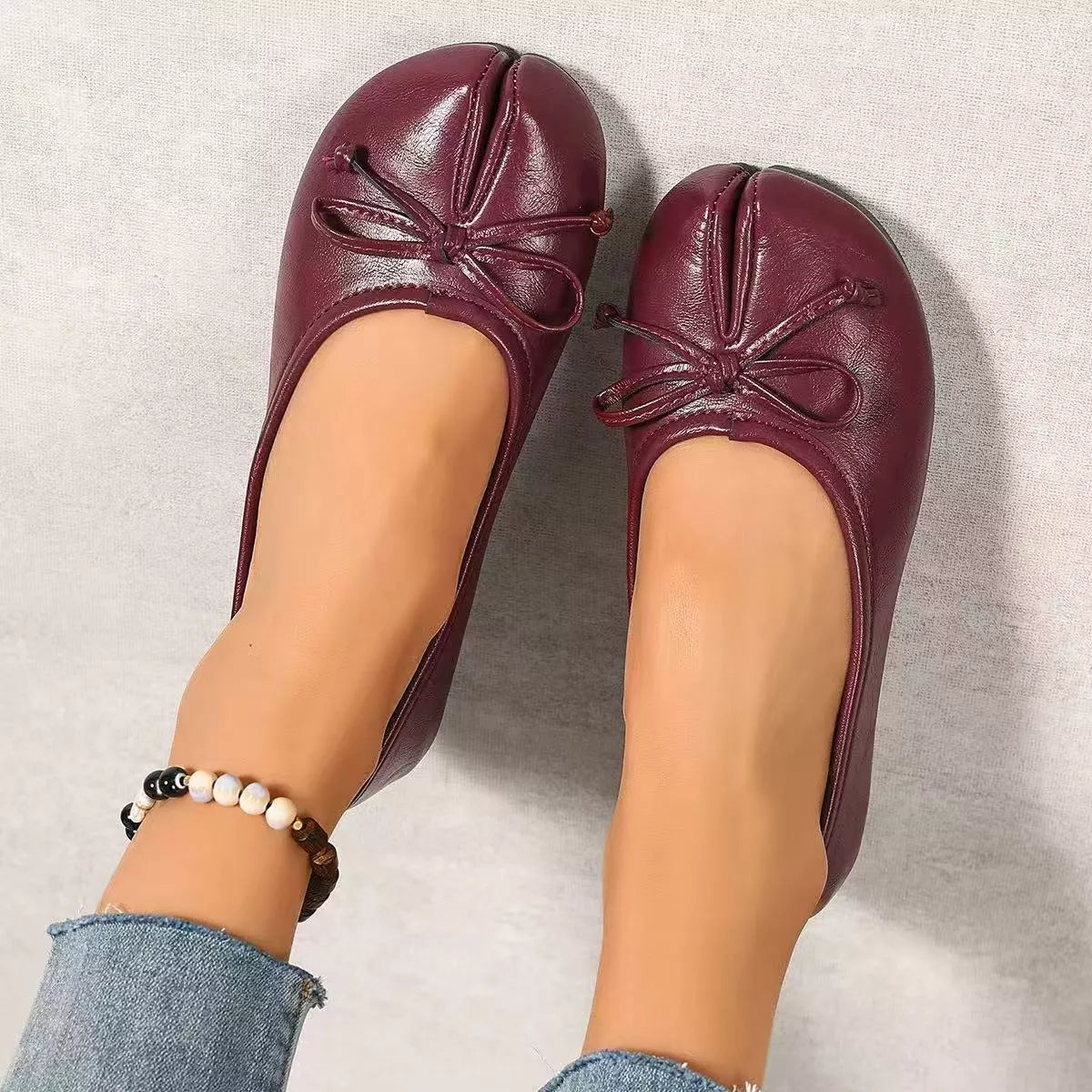 Trendsi Bow Decor Split Toe Slip-On Shoes featuring a stylish bow detail and sleek design in black leather.