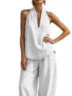 Plus size women's halter neck top and wide-leg pants two-piece set, trendy dress by Trendsi, shown in a stylish, coordinated outfit.