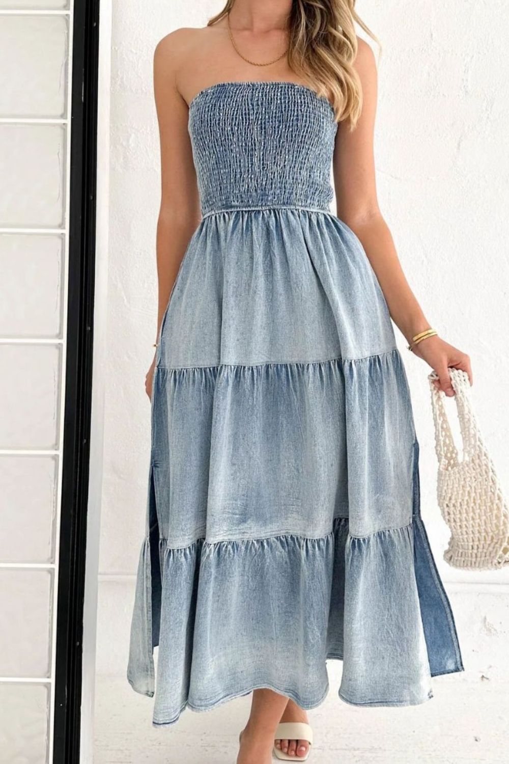 VYSN smocked tube slit tiered denim dress featuring a fitted bodice, tiered skirt, and stylish slit detail on a model.