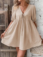 Cotton V-neck tie-front mini dress with puff sleeves, featuring a stylish and feminine design from Trendsi.