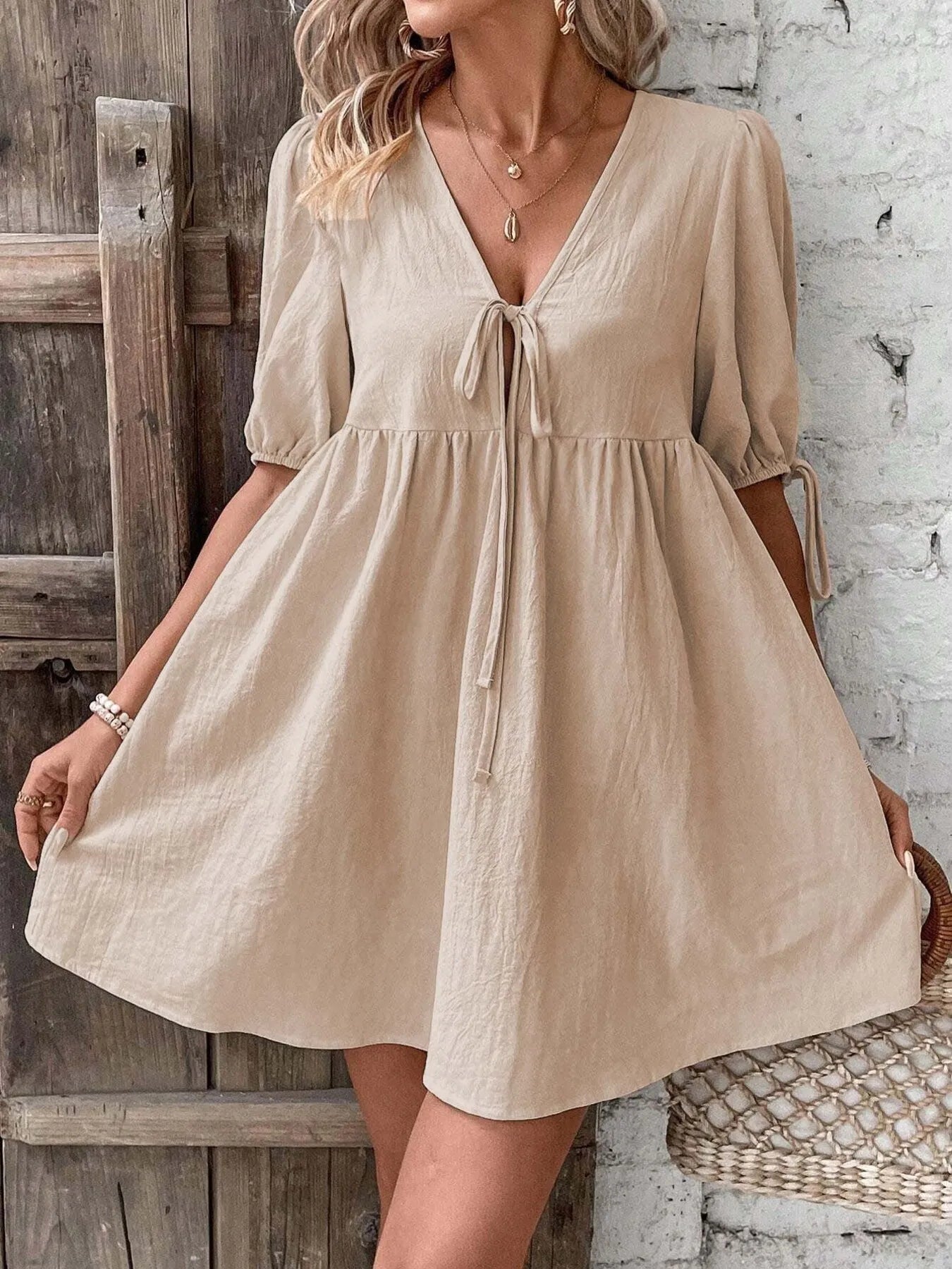 Cotton V-neck tie-front mini dress with puff sleeves, featuring a stylish and feminine design from Trendsi.
