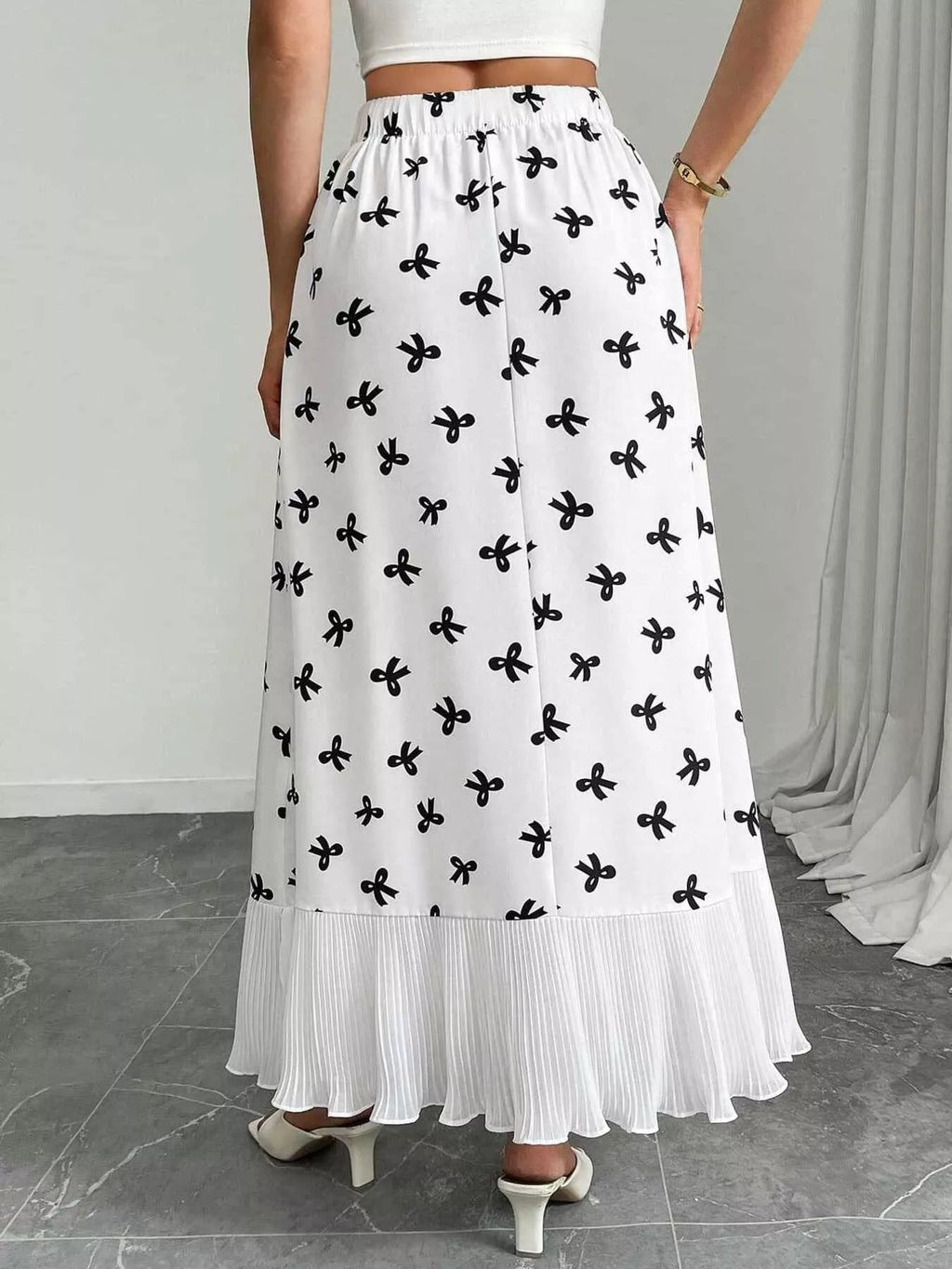 Flowy maxi skirt with bow print and ruffle hem from Trendsi, featuring lightweight fabric and a relaxed, feminine silhouette.