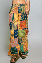Printed patchwork wide leg cotton pants with side drawstring, styled as a dress, featuring vibrant patterns and relaxed fit.