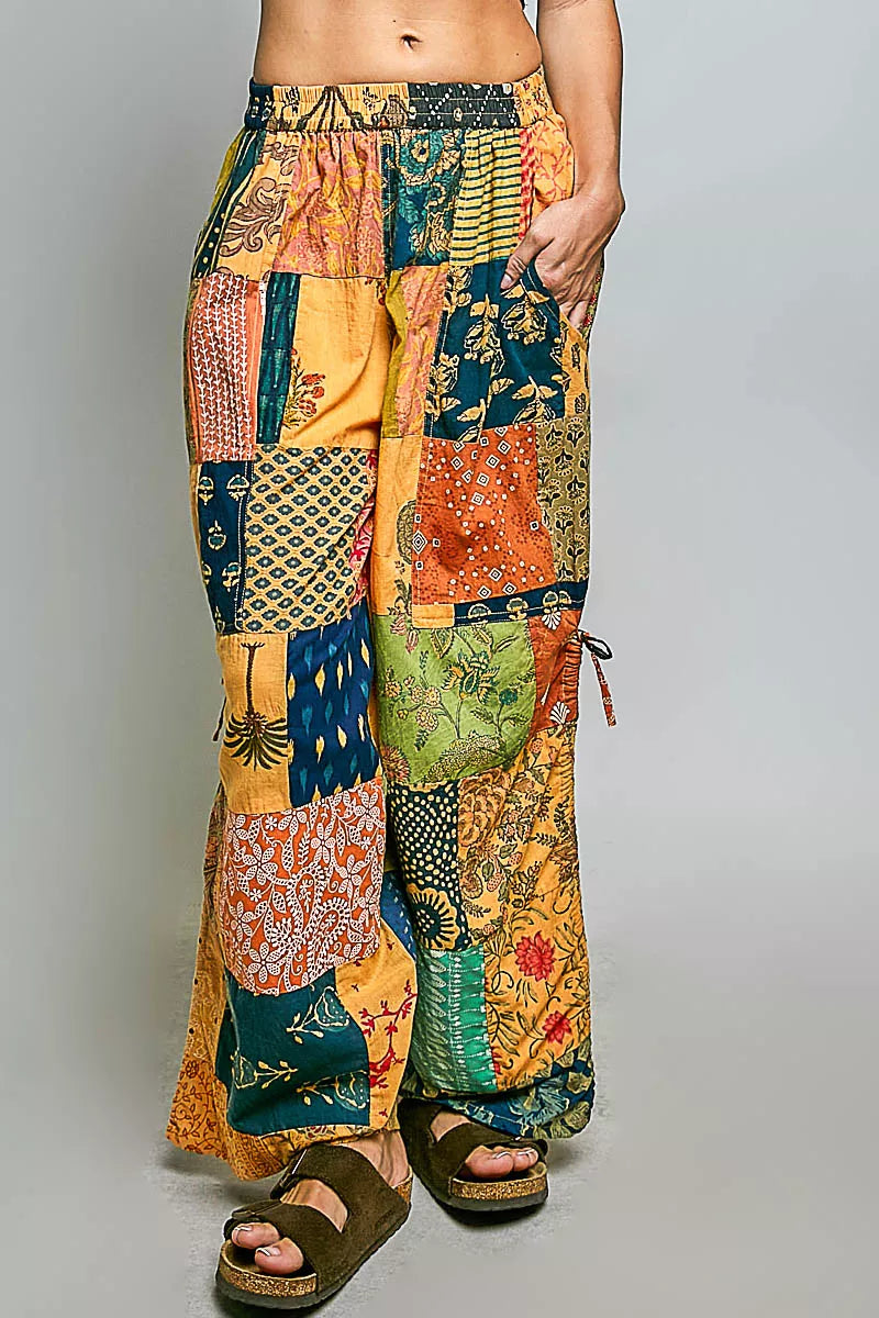 Printed patchwork wide leg cotton pants with side drawstring, styled as a dress, featuring vibrant patterns and relaxed fit.