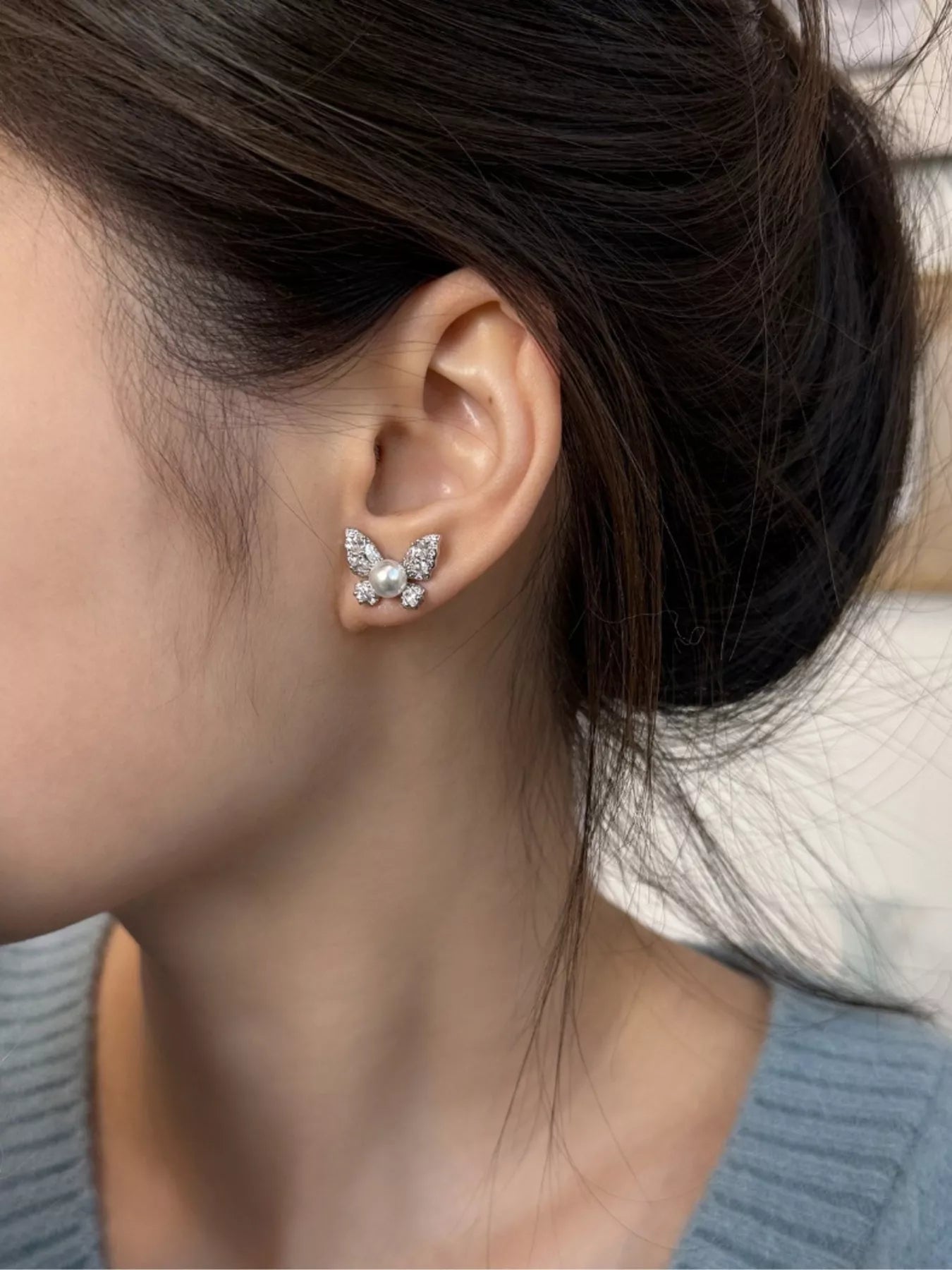 Elegant butterfly pearl stud earrings by Plush Fashion Hub featuring delicate pearl accents and butterfly design.
