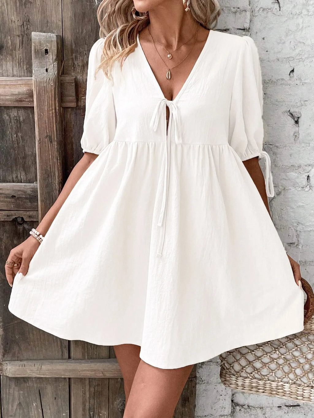 Cotton V-neck tie-front mini dress with puff sleeves, stylish and lightweight, perfect for casual summer wear.