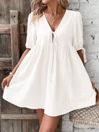 Cotton V-neck tie-front mini dress with puff sleeves, stylish and lightweight, perfect for casual summer wear.