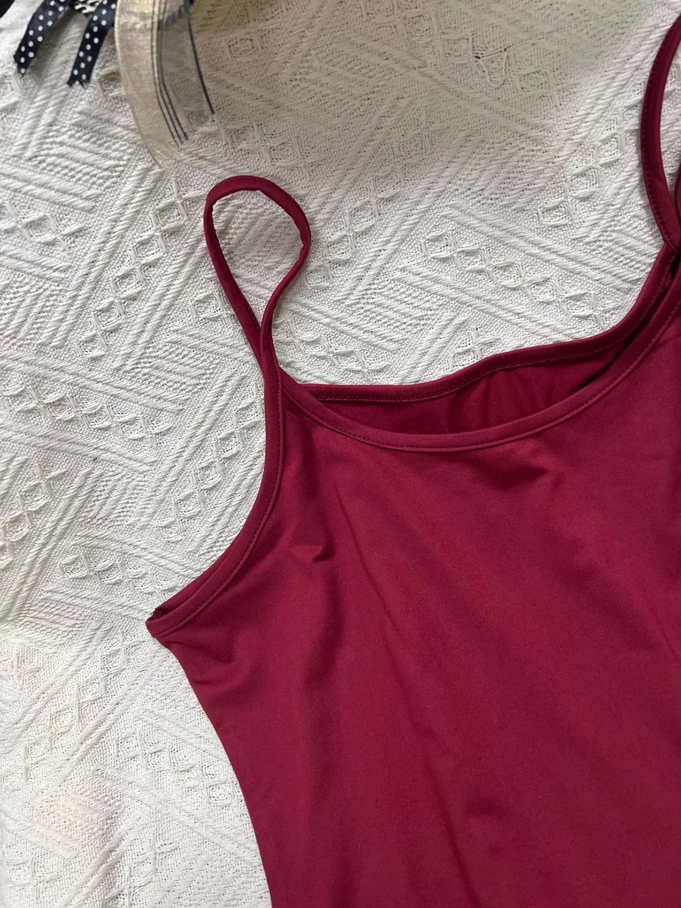 Solid color scoop neck cami tank top by Plush Fashion Hub displayed on a hanger with a smooth fabric texture.