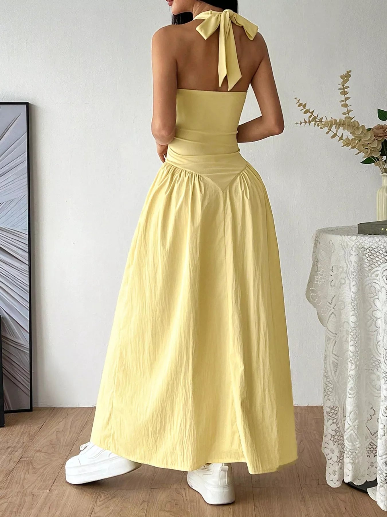 Halter neck ruched maxi dress by Plush Fashion Hub, featuring a flowing silhouette and gathered fabric detail.