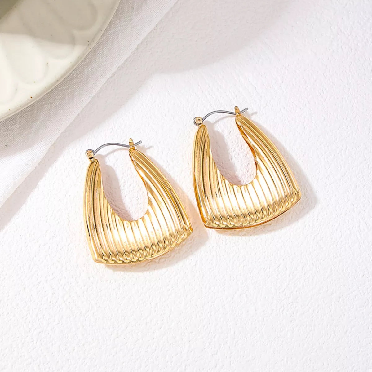 18K gold-plated alloy ribbed triangular hoop earrings with a modern geometric design, displayed on a white background.