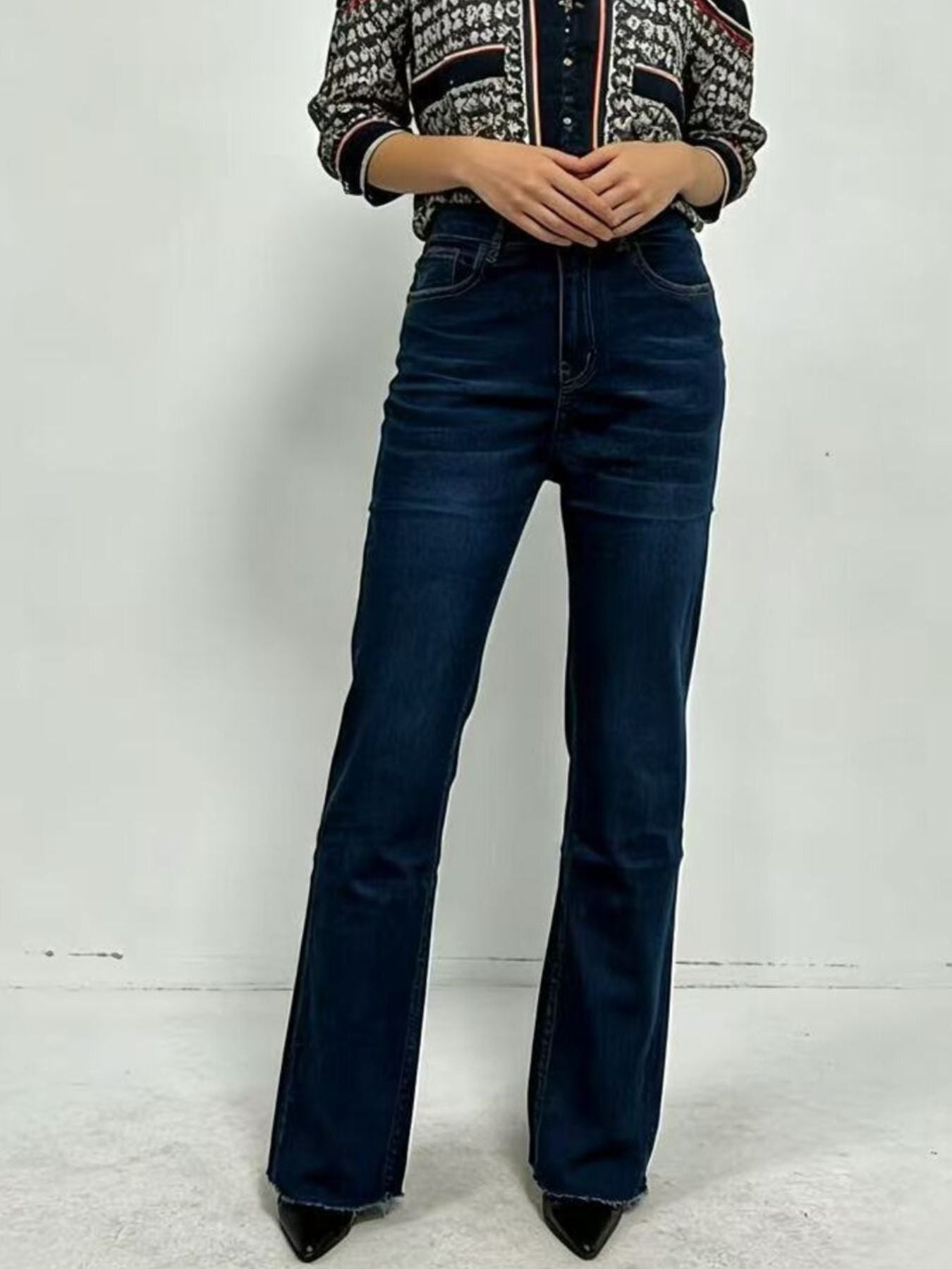 Plush Fashion Shop high-waisted bootcut denim jeans shown on a model, featuring classic blue wash and tailored fit.