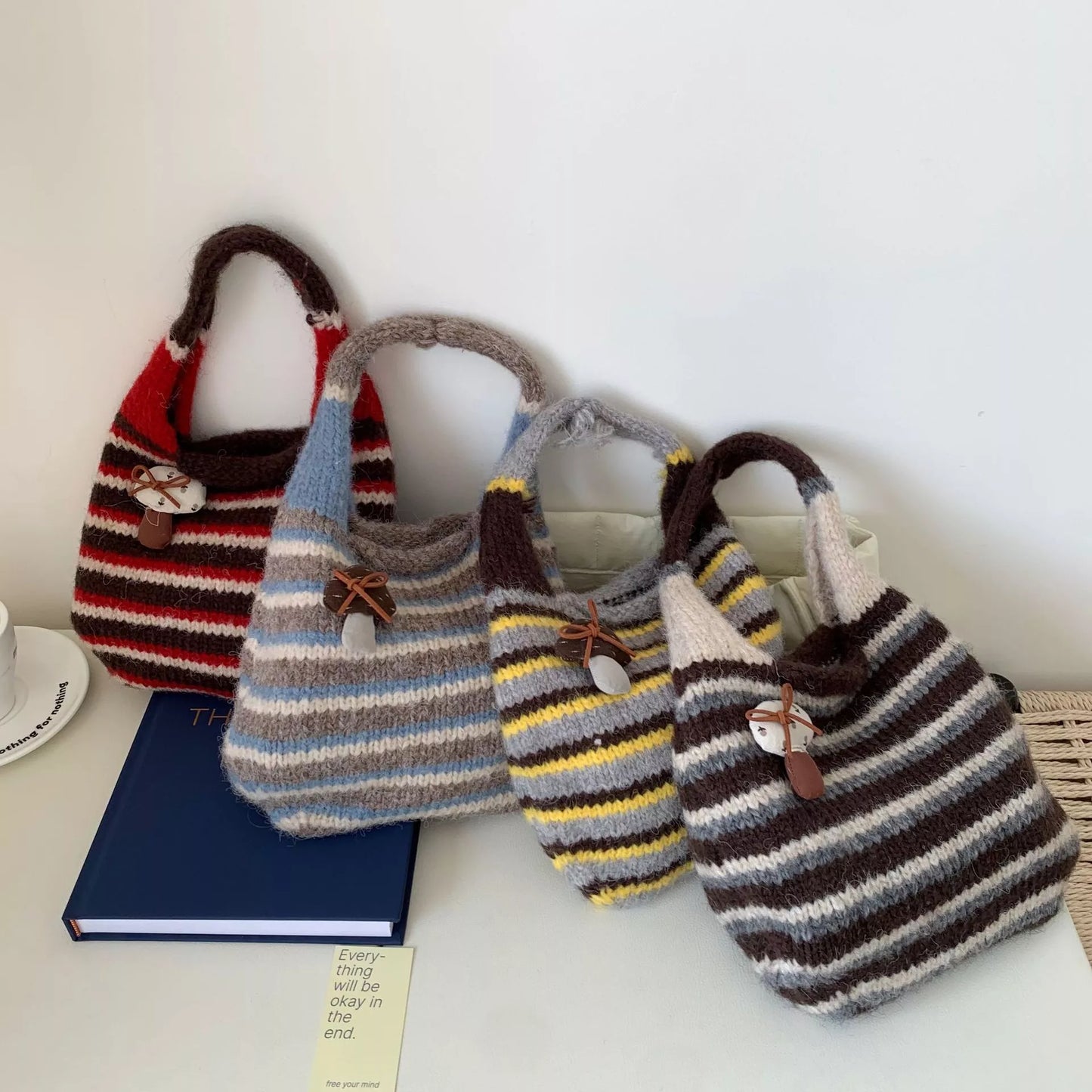 Knitted striped handbag from Plush Fashion Hub featuring a woven design with colorful horizontal stripes and a sturdy handle.