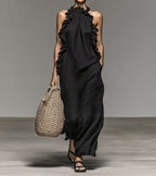 Flowy beige halter neck sleeveless dress with ruffles and pockets, casualwear by Plush Fashion Hub, shown on a model.