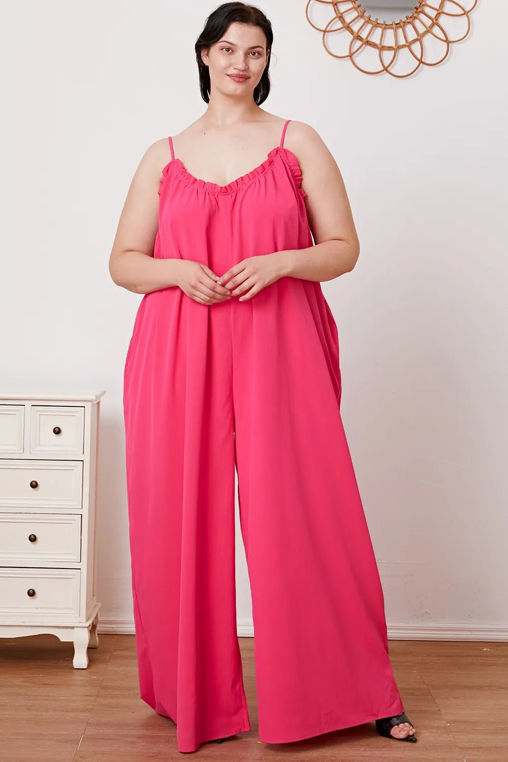 Women's ruffle trim tie-back cami jumpsuit with pockets, trendy women's apparel by Trendsi, shown with ruffle details and waist tie.