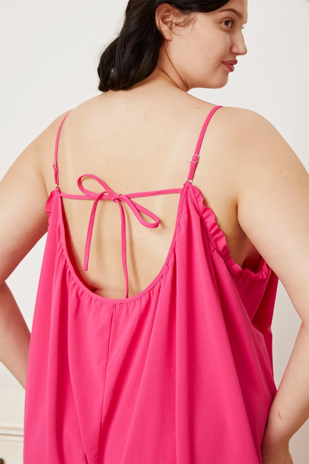 Women's ruffle trim tie-back cami jumpsuit with pockets, from Trendsi, featuring a sleeveless design and stylish ruffle details.