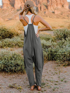 Women's sleeveless V-neck wide-leg jumpsuit with pockets, trendy women's apparel by Trendsi, shown in a full-length image.